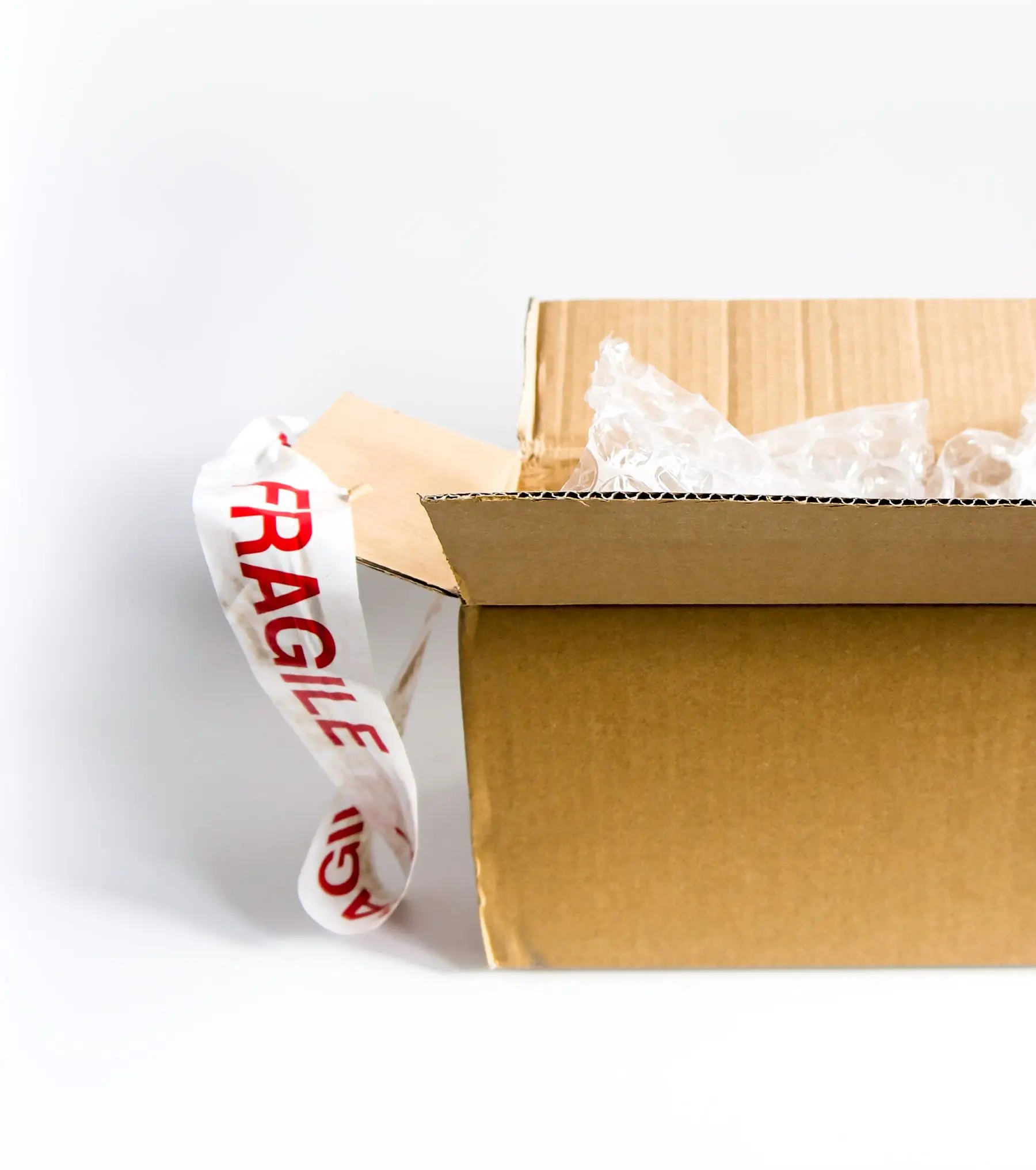 Packed cardboard boxes marked fragile, ready to be loaded into a booked goods vehicle